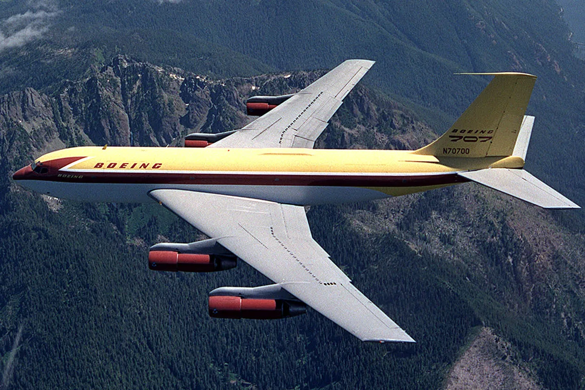 Dash 80 air to air photo, showing the aircraft passing over the Olympic Peninsula with Lake Cushman, Puget Sound and Mt. Rainier in the background. By Joe Parke